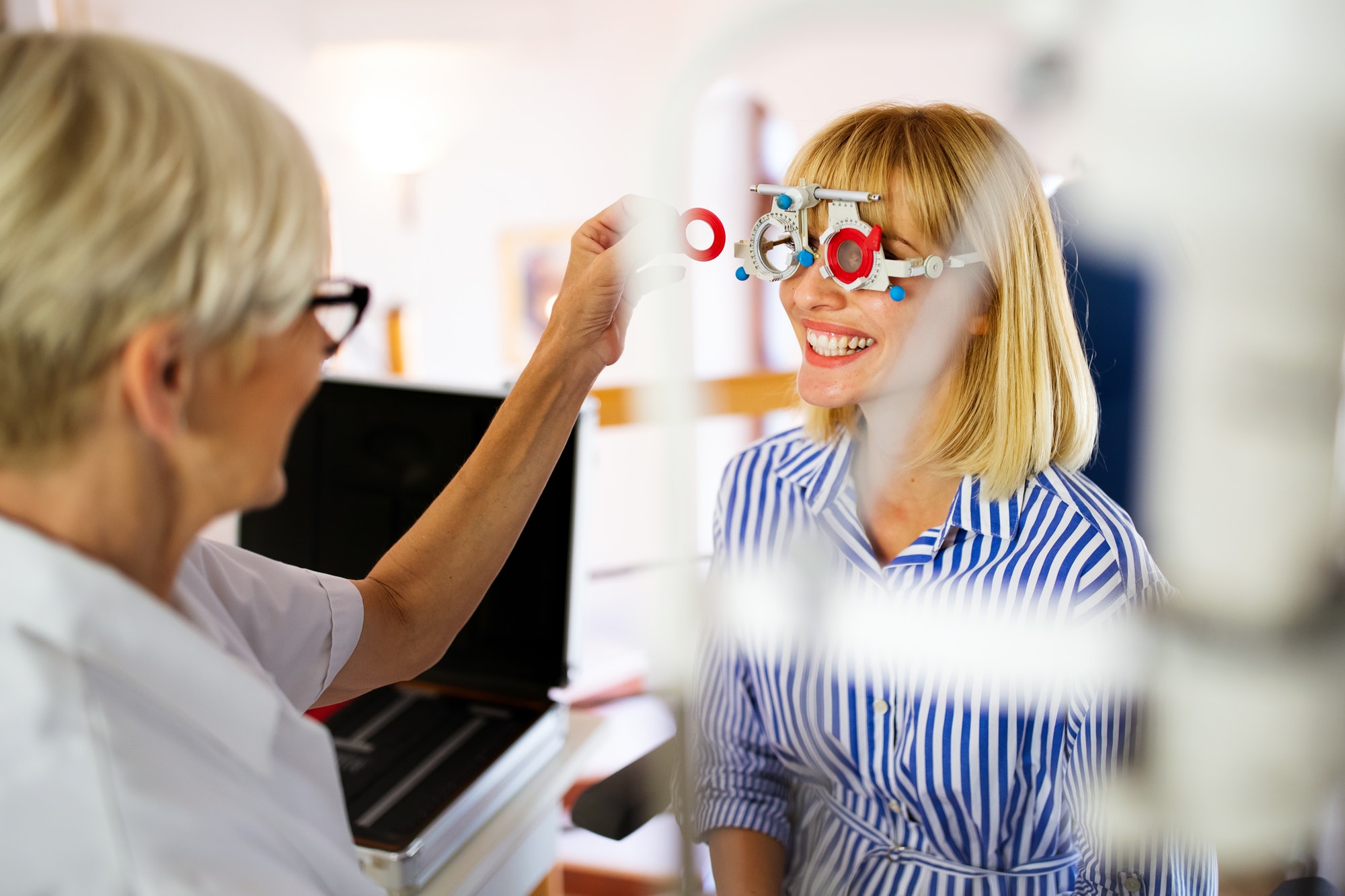 Young woman taking an eyesight test examination at an optician clinic